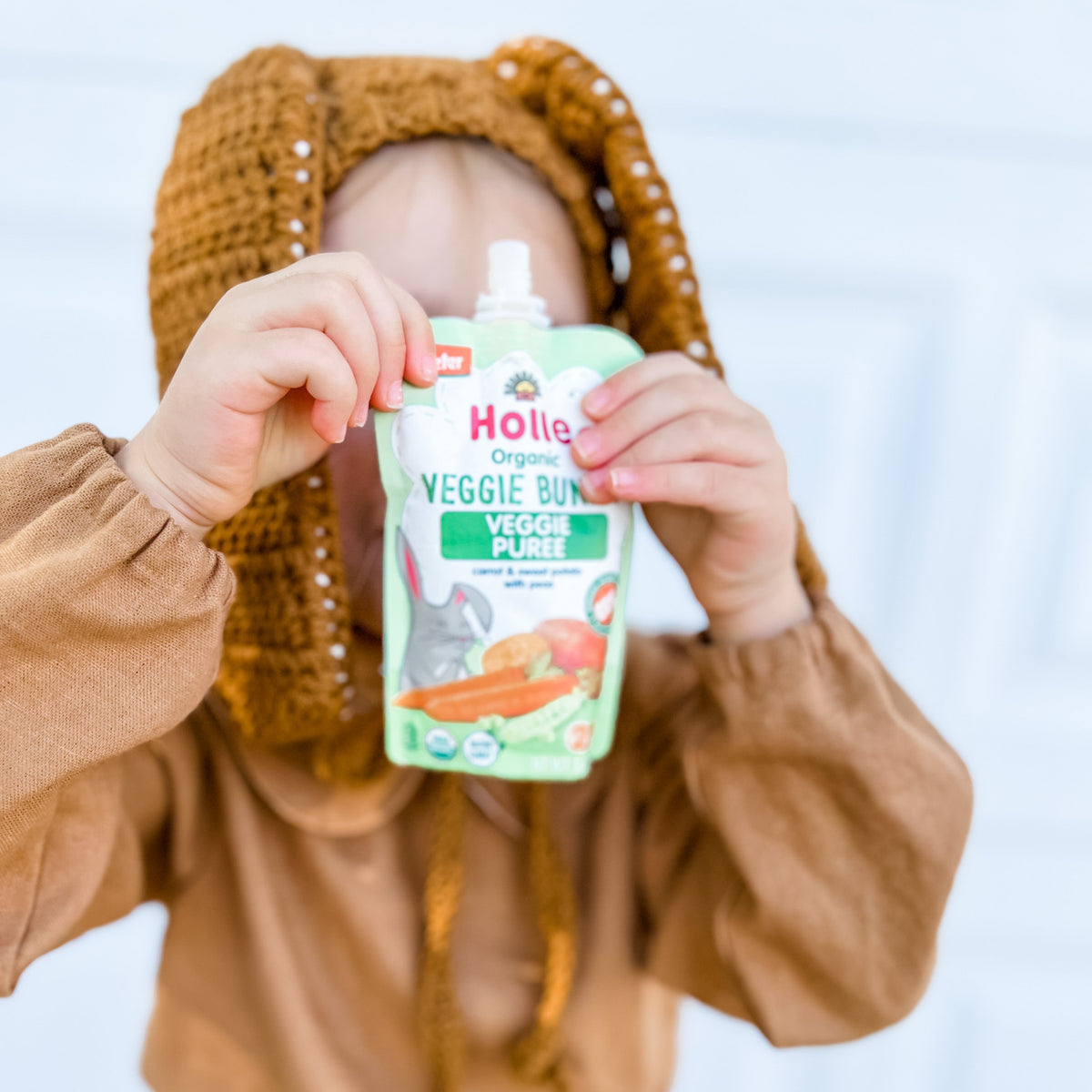 child holding up veggie bunny pouch