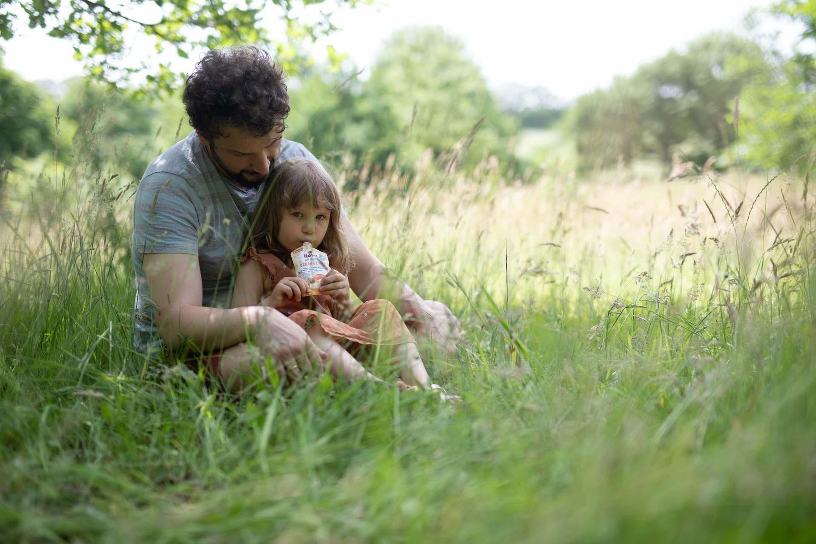 kid with parent eating pouch 