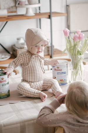 baby with milk tins