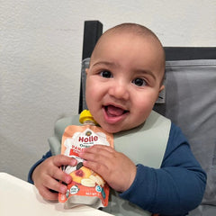 baby in high chair with panda peach pouch