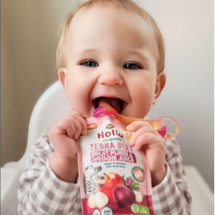 baby eating zebra beet pouch in high chair