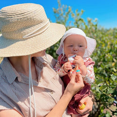 mom and baby enjoying panda peach outside in the sun