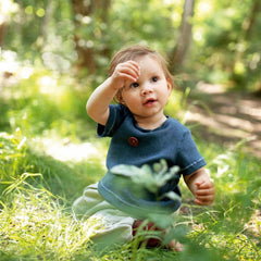 baby playing outside in the forest