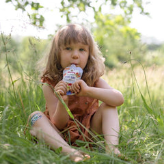 toddler eating blue bird pouch outside