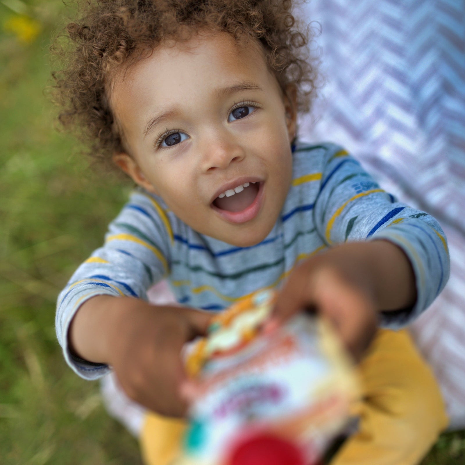 baby handing the camera a Holle pouch