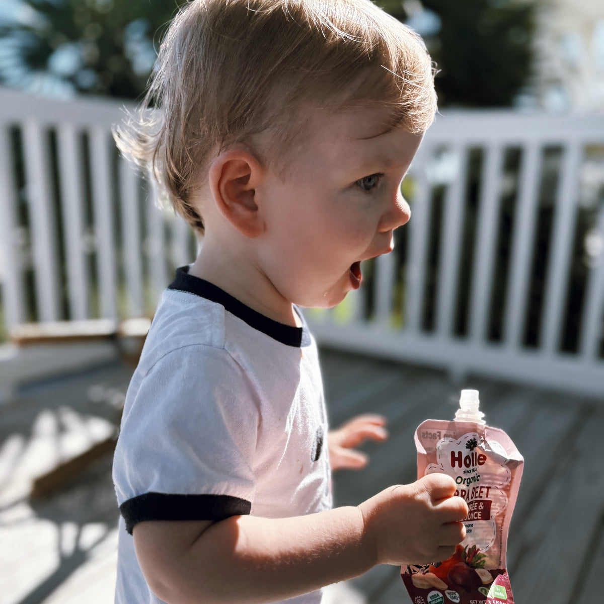 child enjoying zebra beet pouch. playing with zebra beet pouch in-hand