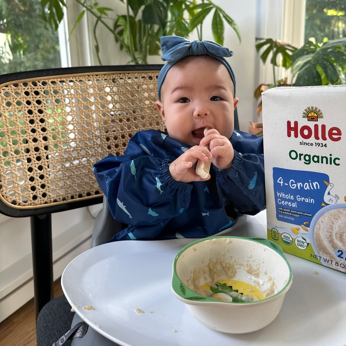 baby eating 4-grain cereal at a table